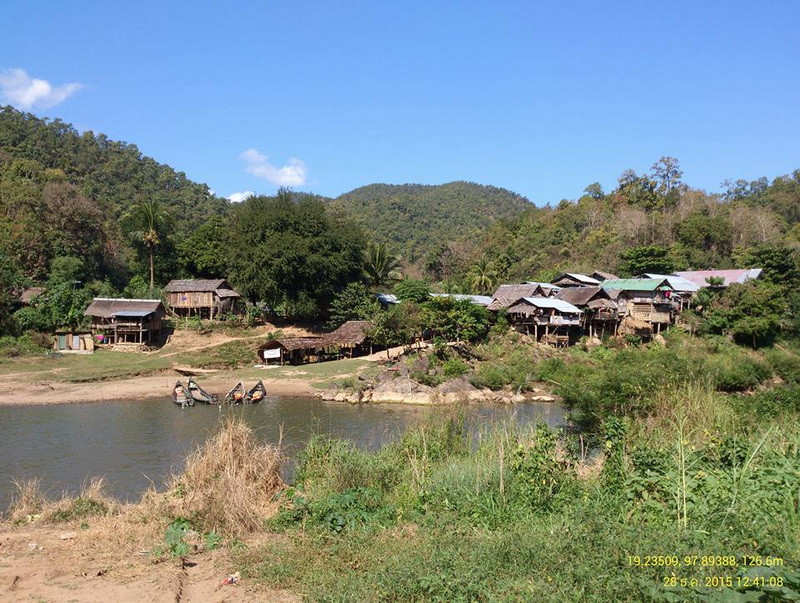 Scenic River Village at Ban Nam Phiang Din Riverside village with wooden houses and lush greenery under a blue sky at Ban Nam Phiang Din.