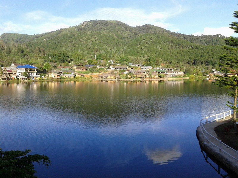 Scenic Mountain River View at Ban Rak Thai Calm river reflecting village and green mountains in the background at Ban Rak Thai.