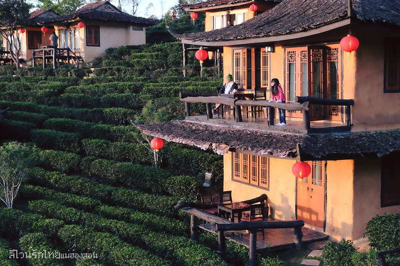 Traditional Building with Balcony View at Ban Rak Thai People relaxing on balcony of traditional building with red lanterns and lush terraces at Ban Rak Thai.