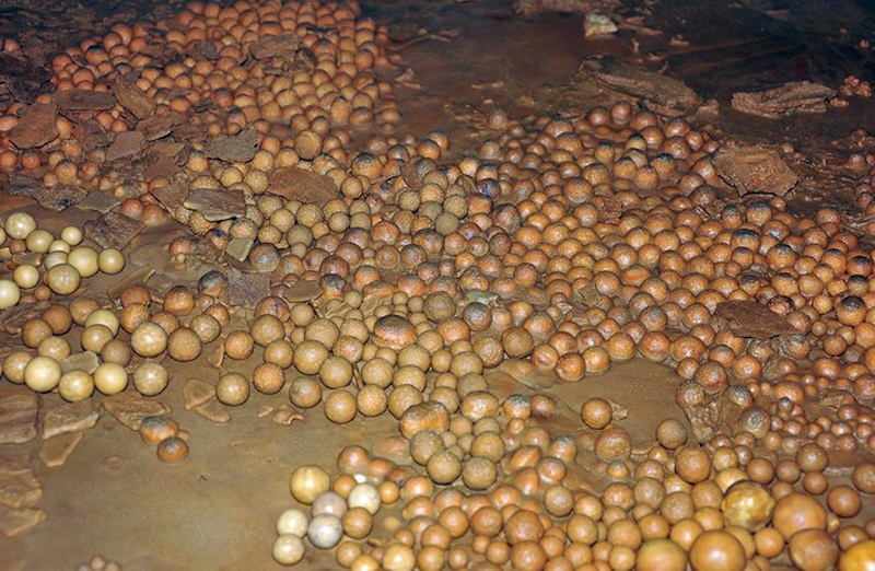 Cave Floor with Small Stones at Mae Lana Cave Small, round stones scattered on a muddy floor inside a cave at Mae Lana Cave.