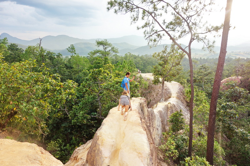 Hiking Trail with Mountain View at Pai Canyon Children walking on a narrow rocky trail surrounded by trees and mountains at Pai Canyon.