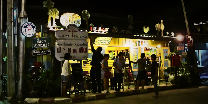 Night Scene at Local Shop at Pai Walking Street People gather outside a brightly lit shop with colorful signs at night at Pai Walking Street.