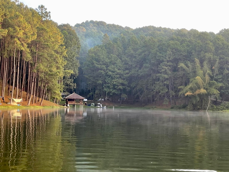 Peaceful Lake Scene at Pang Ung A serene lake with trees and a pavilion on the shore, surrounded by lush greenery at Pang Ung.