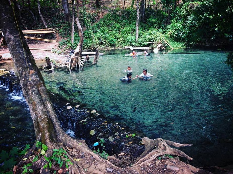 Natural Forest Pool at Sai Ngam Hot Spring People enjoying swimming in a natural forest pool with lush green surroundings at Sai Ngam Hot Spring.