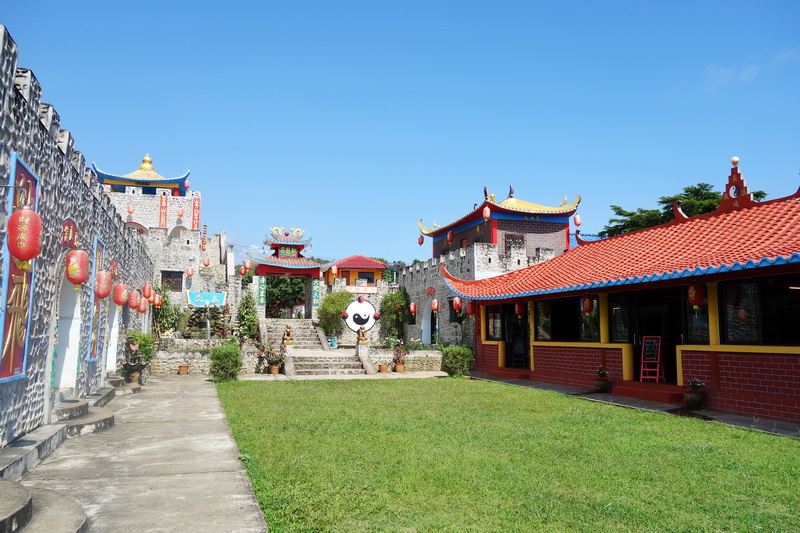 Courtyard with red lanterns, traditional rooftops, and stone walls at Mae Hong Son.