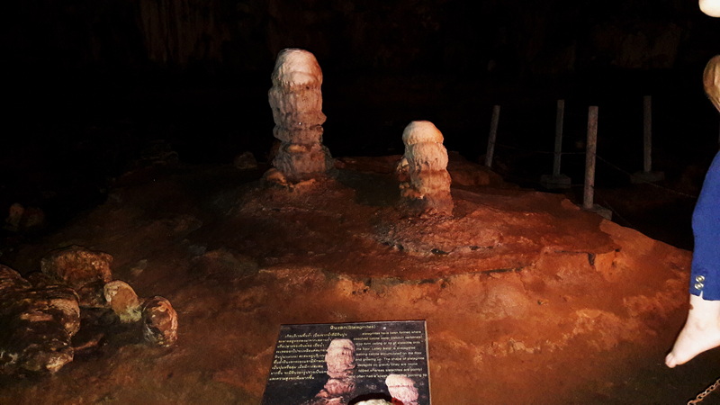 Cave Interior with Stalagmites at Tham Lod Dark cave interior with stalagmites and an informational sign in front at Tham Lod.