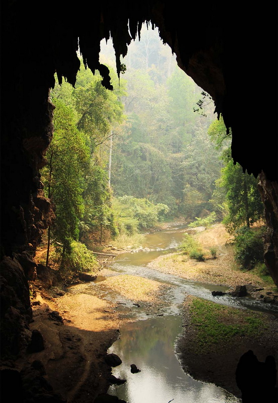 Cave Entrance to Forest River at Tham Lod View from inside a dark cave opening onto a river and forested landscape at Tham Lod.