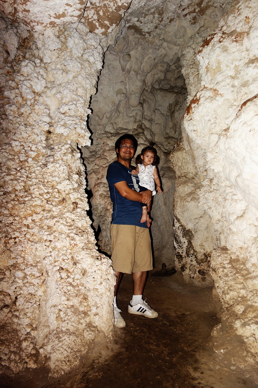 Cave Interior Exploration at Tham Lod Man holding girl inside a narrow subterranean cave with textured walls at Tham Lod.