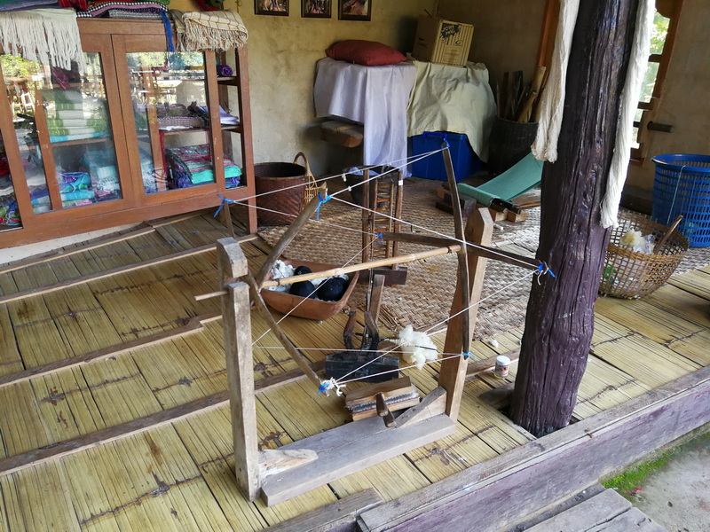Interior room with bamboo floor and a wooden cat toy with cats nearby at Doi Inthanon National Park.