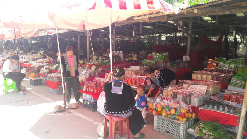 Local Market Scene at Doi Inthanon Hmong Market Market scene with stalls selling dried goods and fruits under red umbrellas at Doi Inthanon Hmong Market.