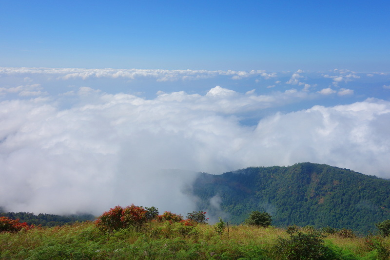 Mountain landscape with clouds and a blue sky above green hills at Doi Inthanon National Park.