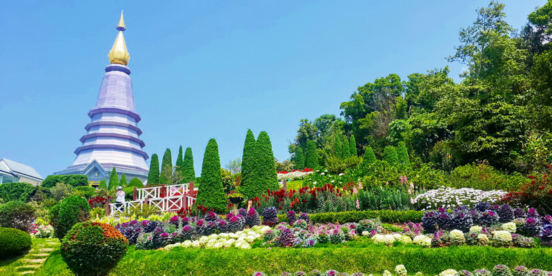 Colorful Garden and Pagoda View at King and Queen Pagodas A vibrant garden with blooming flowers and a tall, golden-spired pagoda in the background at King and Queen Pagodas.