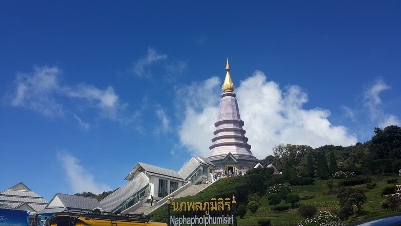 Pagoda at Doi Inthanon at Doi Inthanon National Park White and gold pagoda on a grassy hillside under a blue sky with clouds at Doi Inthanon National Park.