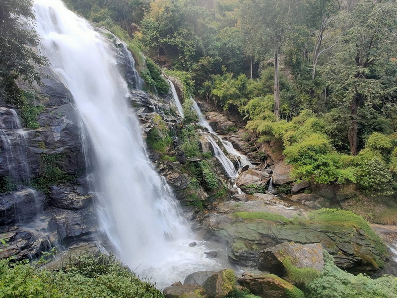 Scenic Waterfall in Forest at Wachirathan Waterfall Tall waterfall flowing over rocks with dense greenery around it at Wachirathan Waterfall.