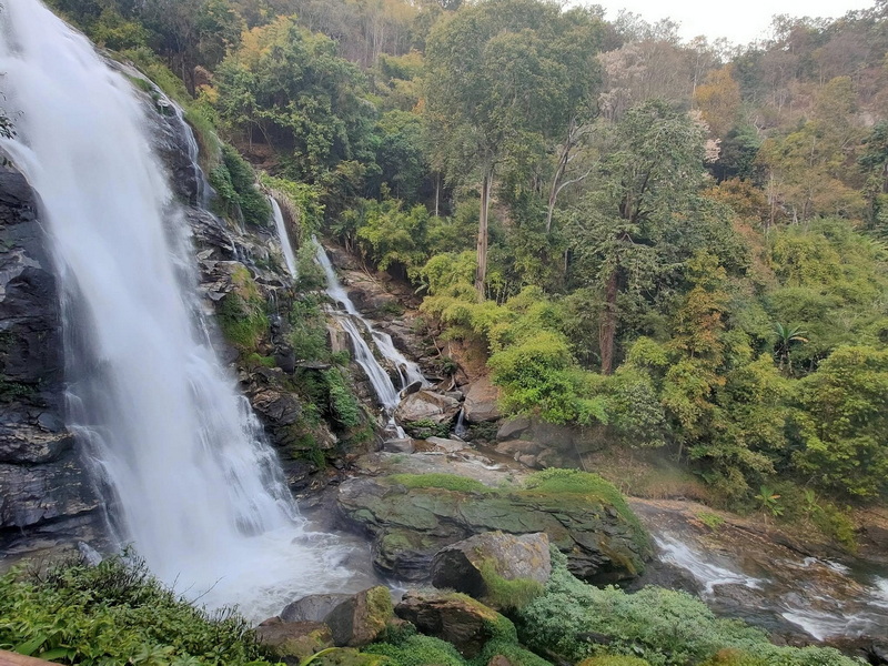 Scenic Waterfall Scene at Wachirathan Waterfall A waterfall flowing over rocks with lush trees in the background at Wachirathan Waterfall.