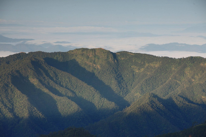 Wide view of green mountain ridges with clouds in the sky at Doi Pha Hom Pok National Park.