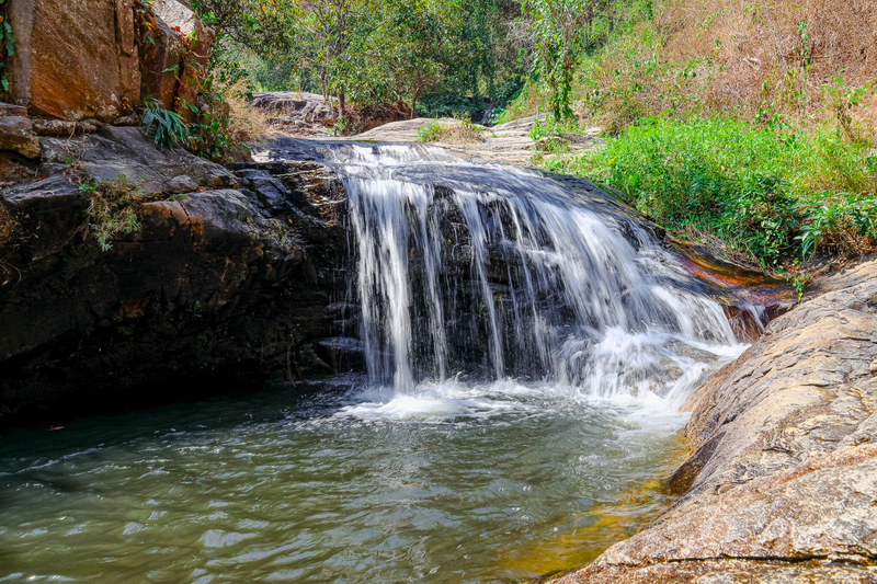 Serene Waterfall Scene at Huai Kaew Waterfall Small waterfall cascading over rocks into a pool with surrounding greenery at Huai Kaew Waterfall.