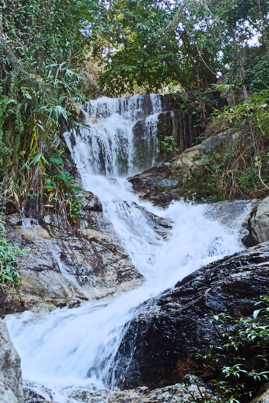 Small Forest Waterfall at Huay Kaew Waterfall A cascading waterfall over rocks amid lush green forest vegetation at Huay Kaew Waterfall.