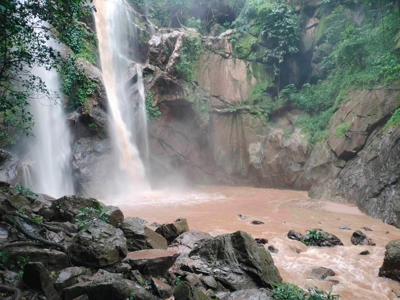 Waterfall cascading into a rocky pool with surrounding green foliage at Doi Suthep-Pui National Park.