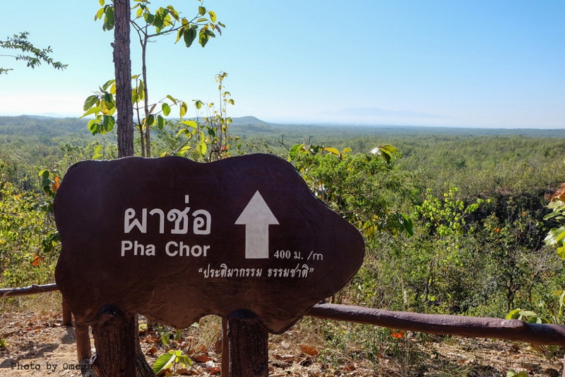 Signpost to Pha Chor at Phar Choi Wooden sign pointing towards Pha Chor with forest and open landscape in the background at Phar Choi.