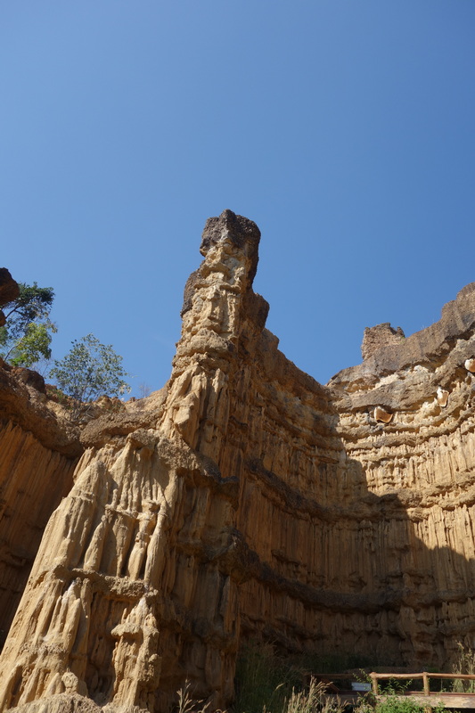 Tall sandstone formation with layered textures in a canyon under clear sky at Phar Choi.