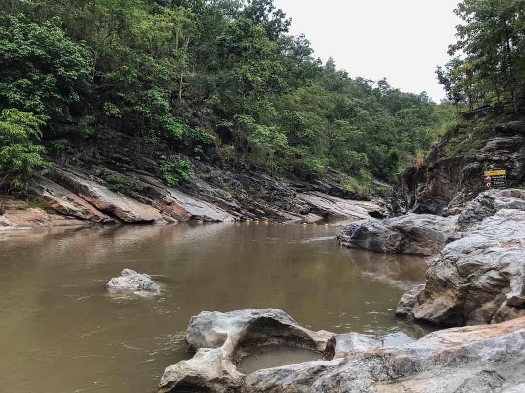 Serene River in Forested Area at Ob Khan National Park A tranquil river with rocks and lush green trees along the banks at Ob Khan National Park.