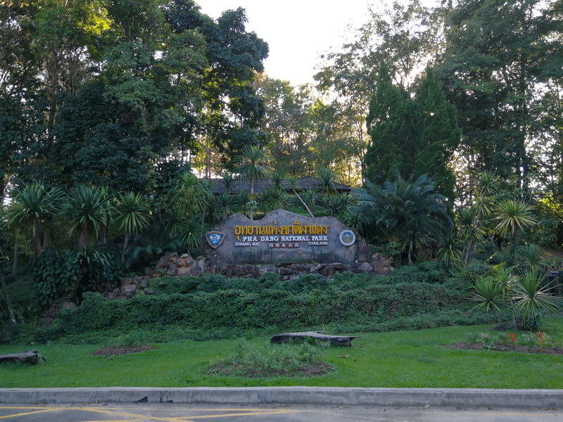Pha Daeng National Park Entrance A sign for Pha Daeng National Park surrounded by greenery and trees.