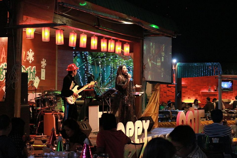 Nighttime Live Music Performance at Things To Do In Chiang Mai Evening Musicians performing on stage with hanging lanterns and string lights inside a lively venue at night at Things To Do In Chiang Mai Evening.
