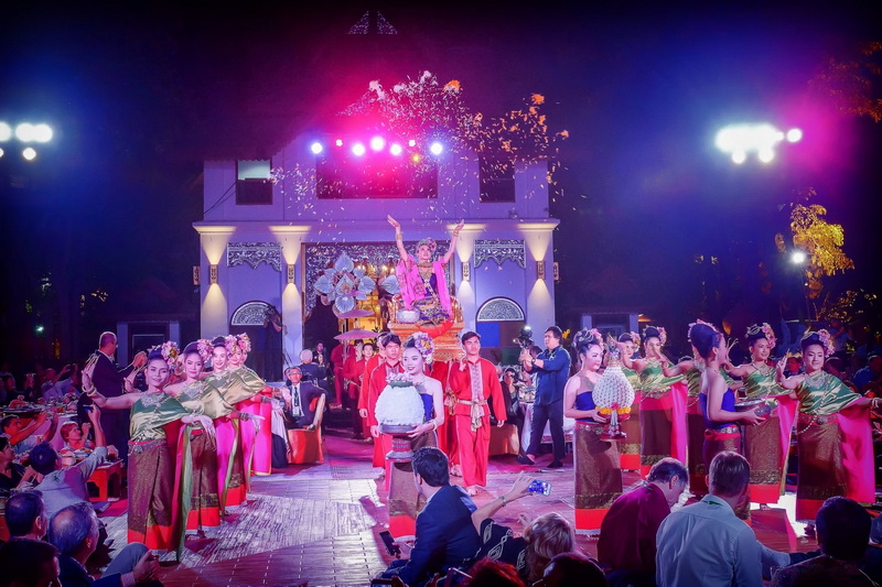 Performers in traditional costumes on stage during a night event with colorful lighting at Night Activities In Chiang Mai.