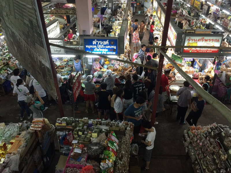 Indoor market filled with shoppers browsing stalls and various products on sale at Chiang Mai Nightlife.