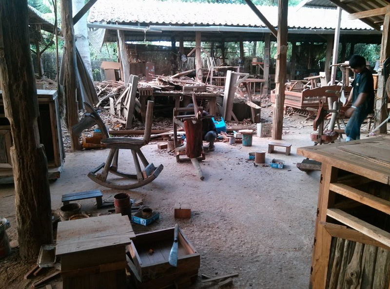 Woodworking Workshop Scene at Baan Tawai A woodworking workshop with chairs, tools, and a person working on wood at Baan Tawai.