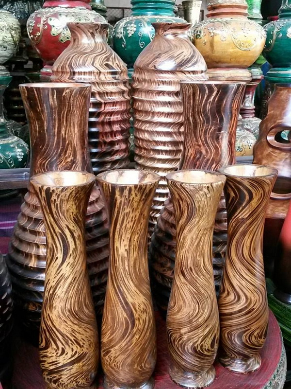 Wooden vases with swirling grain patterns arranged in a shop display at Baan Tawai Wood Carving Village.