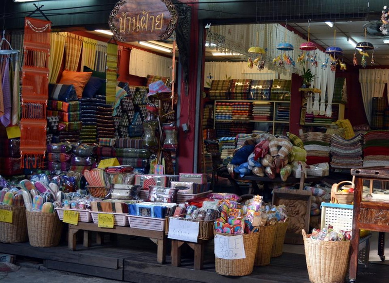 Colorful Textile Market Display at Baan Tawai Shop display with vibrant textiles, cushions, and umbrellas inside a market stall at Baan Tawai.