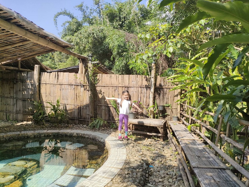 Child by Hot Spring Pool at Ban Yang Pu Toh mineral hotsprings Young girl standing by a small hot spring pool in a lush outdoor setting at Ban Yang Pu Toh mineral hotsprings.