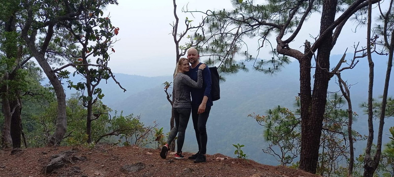 A couple standing on a wooded viewpoint, possibly near Ban Yang Pu Toh trekking.