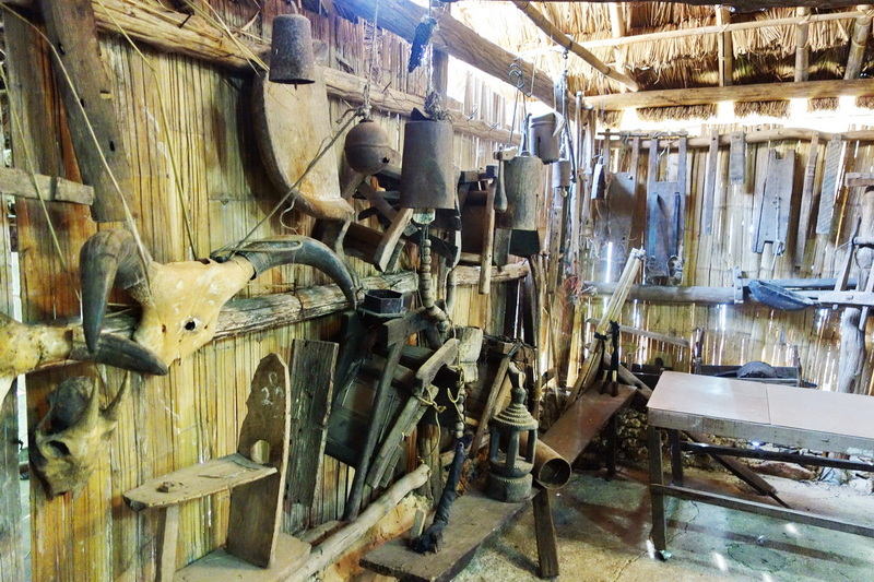 Old rustic workshop with animal skulls, horns, and tools hanging inside at Hmong Doi Pui Village.