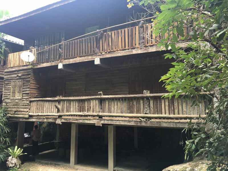 Wooden House with Balcony at Mae Kanpong Village Traditional wooden house with balcony and surrounding green foliage at Mae Kanpong Village.
