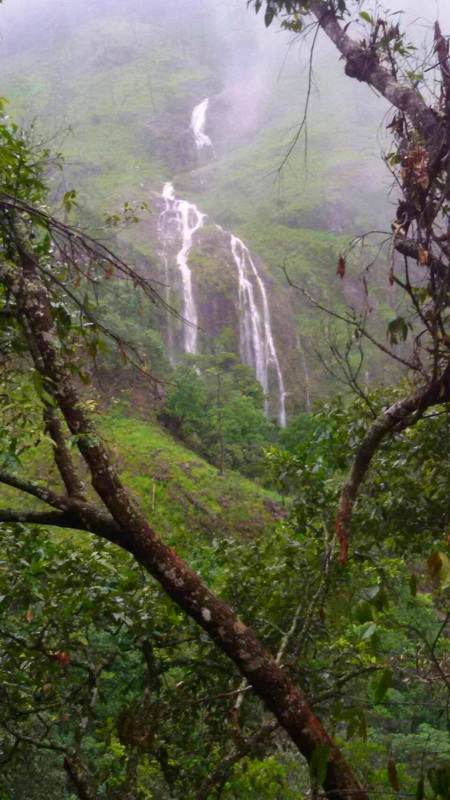Misty Mountain Waterfall at Pang Hi Village Waterfall flowing down a green mountain slope surrounded by trees and mist at Pang Hi Village.