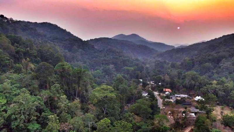 Sunset over Forest Valley at Pang Hi Village Aerial view of a forest valley with buildings and winding roads during sunset at Pang Hi Village.