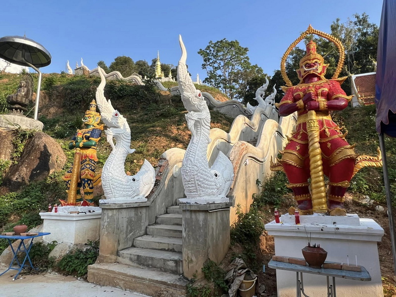 Statues at Hillside Entrance at Pang Hi Village Large mythological creature and demon statues beside staircase on hillside at Pang Hi Village.