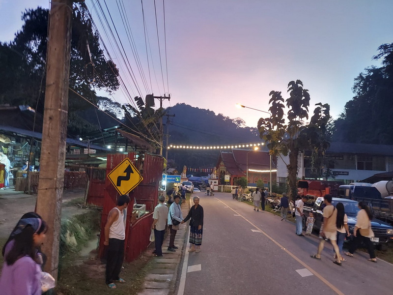 Nightview of Local Street and Temple at Pang Hi Village Street scene with people, shops, vehicles, and a temple with a clock tower at dusk at Pang Hi Village.