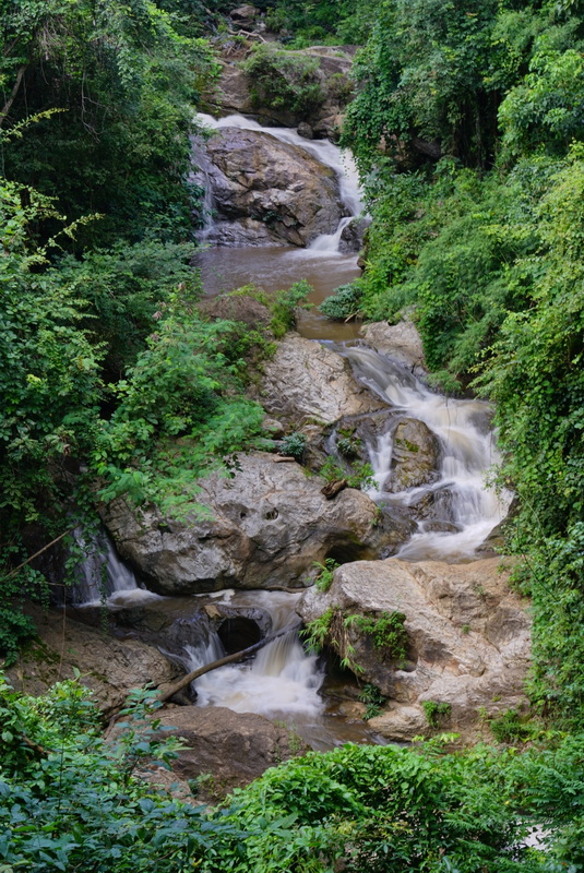 Scenic Waterfall in Nature at Mae Sa Waterfall Multiple levels of waterfall flowing over rocks in lush greenery at Mae Sa Waterfall.