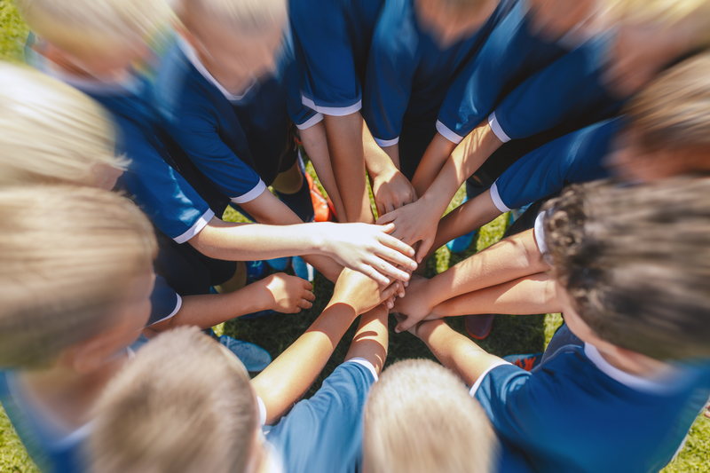 Group of Children in Uniform at Summer Camp In Chiang Mai Children in blue uniforms joining hands in circle outdoors during daytime at Summer Camp In Chiang Mai.